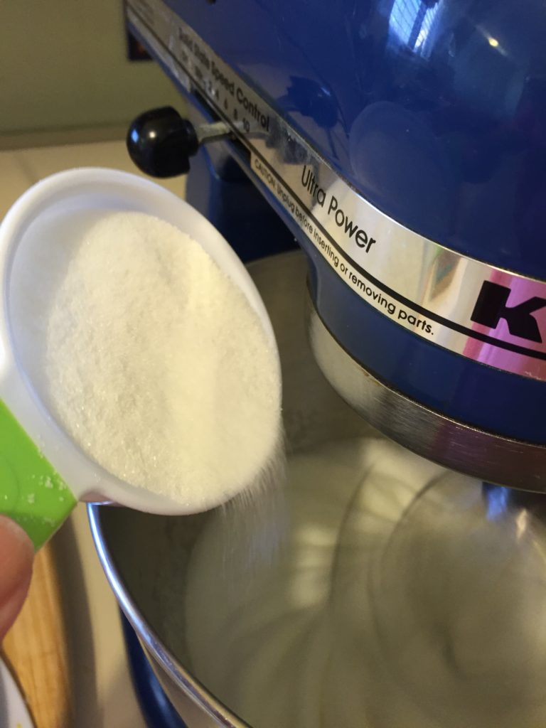 Keep whipping the egg whites on medium high while slowly adding in the sugar